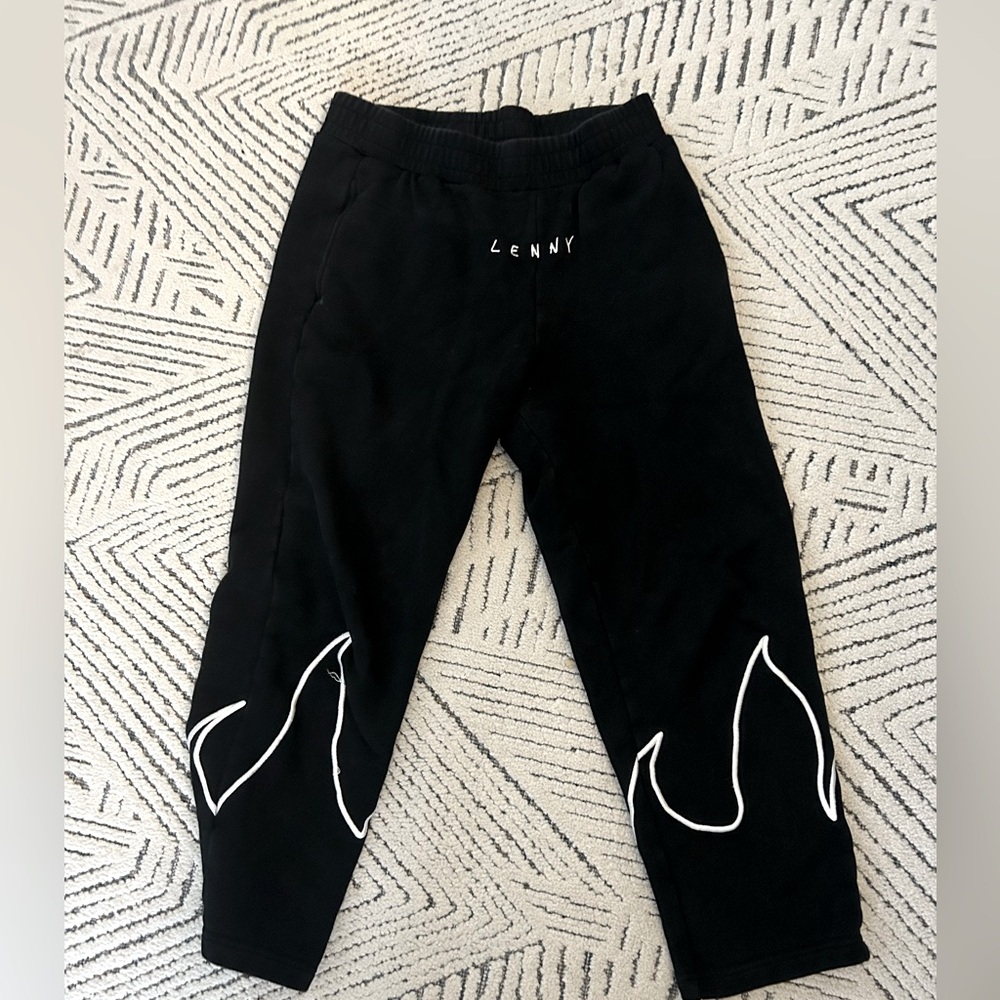 Black sweatpantss with fire on the bottom of the pants.